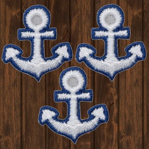 May include: Three white anchor patches with blue outlines. The anchors are embroidered and have a classic design.