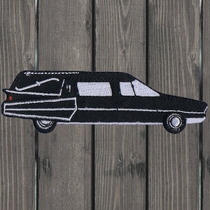 May include: Black and white embroidered patch of a hearse, a type of car used for funerals.