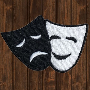 Può includere: Toppa ricamata in bianco e nero di due maschere teatrali, una sorridente e l'altra accigliata.