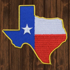 Peut inclure: Un patch brodé en forme de l'état du Texas, avec les couleurs bleu, blanc et rouge. Le patch a un contour jaune et une étoile blanche dans la section bleue.