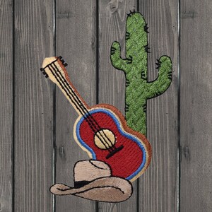 May include: Embroidered patch featuring a red guitar, a brown cowboy hat, and a green cactus on a wood background.