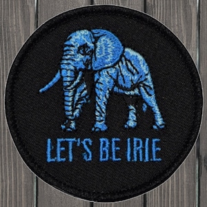 Peut inclure: Un patch brodé noir et bleu avec une silhouette d'éléphant et le texte "Let's Be Irie".