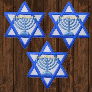 May include: Three white embroidered iron-on patches with a blue Star of David design and a menorah in the center. The menorah is blue with yellow flames.
