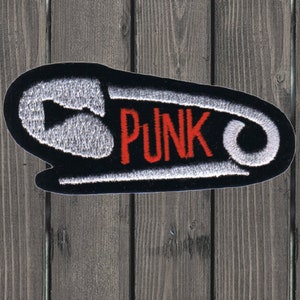 May include: A black and white safety pin with the word "PUNK" in red embroidery.