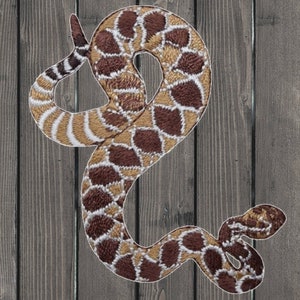 May include: Embroidered patch of a brown and tan rattlesnake with a white background. The snake is curled in a coil with its head raised.