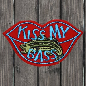 May include: Red embroidered patch with a fish and the text "Kiss My Bass" in blue.