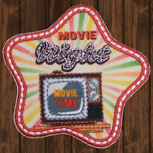 May include: A star-shaped patch with a red, white, and green striped background. The patch features a vintage television with the words "Movie Time" on the screen. The text "Movie Night" is written in a glittery font above the television.