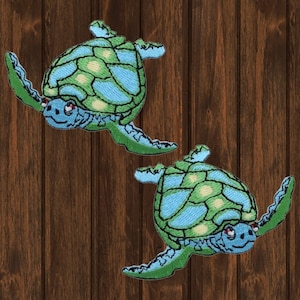 May include: Two green and blue embroidered sea turtle patches. The turtles are facing right and have a light green shell with blue accents.