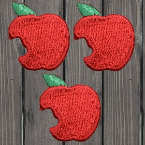 May include: Three red felt apple patches with a bite taken out of them and green felt stems.