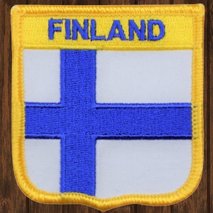 May include: A blue and white Finnish flag patch with a yellow border and the word "FINLAND" in blue letters on the top.