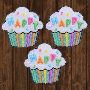 Puede incluir: Tres parches termoadhesivos en forma de cupcake blancos con rayas arcoíris y la palabra "HAPPY" en letras de colores.