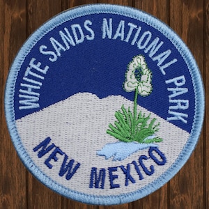 Puede incluir: Parche bordado con el logotipo del Parque Nacional de White Sands. El parche tiene un fondo azul con montañas blancas, una planta de yuca verde y el texto "White Sands National Park New Mexico".
