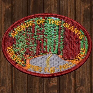 Op de afbeelding: Geborduurde patch met de Avenue of the Giants in Californië. Het ontwerp toont een weg door sequoia's, met de tekst "Avenue of the Giants, Redcrest, Myers Flat, Phillipsville."