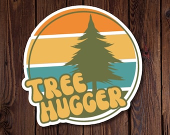 Könnte beinhalten: Ein runder Aufkleber mit einem Retro-Sonnenuntergangsdesign, das einen grünen Kiefernbaum in der Mitte zeigt. Der Text "Tree Hugger" ist in einer groovigen Schrift in Gelb und Grün geschrieben.