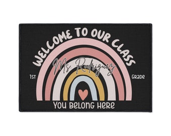 May include: Black welcome mat with a rainbow design and the text "Welcome to our class 1st Grade Ms. Rodriguez You belong here".