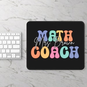 May include: Black mouse pad with the text "MATH Mrs. Brown COACH" in colorful, retro-style letters.