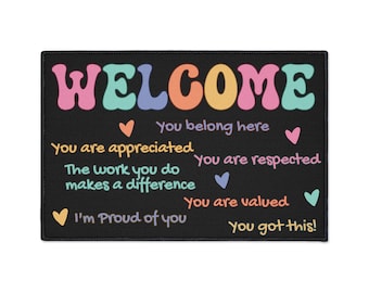 Puede incluir: Una alfombra de bienvenida negra con texto de colores que dice "WELCOME", "You belong here", "You are appreciated", "You are respected", "The work you do makes a difference", "You are valued", "I'm Proud of you" y "You got this!"