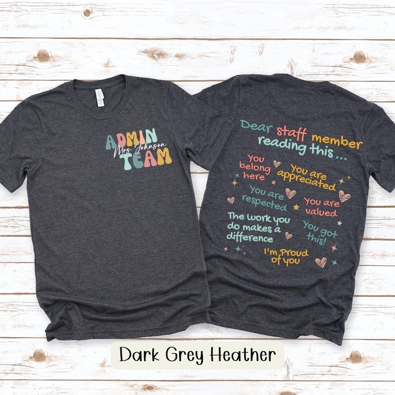 Op de afbeelding: Donkergrijs heather t-shirt met de tekst "ADMIN TEAM Mrs. Johnson" op de voorkant en de tekst "Beste medewerker die dit leest... Je hoort hier Je wordt gewaardeerd Je wordt gerespecteerd Je wordt gewaardeerd Het werk dat je doet maakt een verschil Je hebt het gedaan! Ik ben trots op je" op de achterkant.