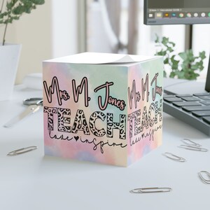 May include: A pastel pink, blue and yellow ombre notepad with the text "Mrs. M. Jones Teach love inspire" in black and pink lettering. The letters are decorated with a leopard print pattern.