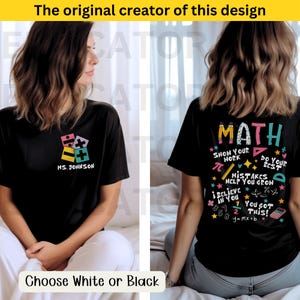 Peut inclure: T-shirt noir avec un motif math&eacute;matique color&eacute; au dos. Le motif comprend le mot "MATH" en grandes lettres, ainsi que divers symboles et &eacute;quations math&eacute;matiques. Le devant du t-shirt pr&eacute;sente un motif plus petit avec des symboles math&eacute;matiques color&eacute;s et le texte "MS. JOHNSON".