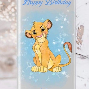Puede incluir: Un envoltorio de chocolate azul y blanco con una imagen de dibujos animados de Simba de El Rey León. El envoltorio dice "Feliz cumpleaños" y tiene un espacio para un nombre.
