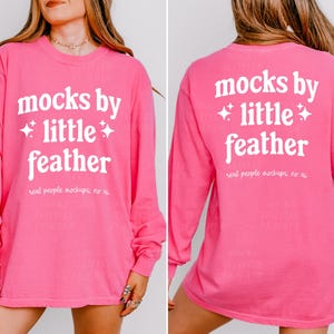 May include: Pink long-sleeved t-shirt with the text "mocks by +little+ feather" in white on the front and back. The text "real people mockups, no ai" is also printed on the back.