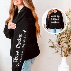 Puede incluir: Una sudadera negra de manga larga con texto blanco en la manga que dice Sleeve Mockup y mocksbylittlefeather, con un recuadro circular que muestra el frente con el texto mocks by little feather y detalles de estrellas.