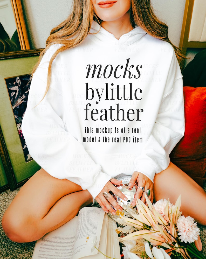 Puede incluir: Sudadera con capucha blanca con el texto "mocks bylittle feather this mockup is of a real model & the real POD item" impreso en la parte delantera.