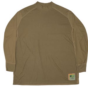 Könnte beinhalten: Olivgrünes Langarmshirt mit Stehkragen. Das Shirt hat verstärkte Nähte an den Schultern und einen kleinen Aufnäher auf der unteren rechten Seite. Hergestellt aus leichtem Material.