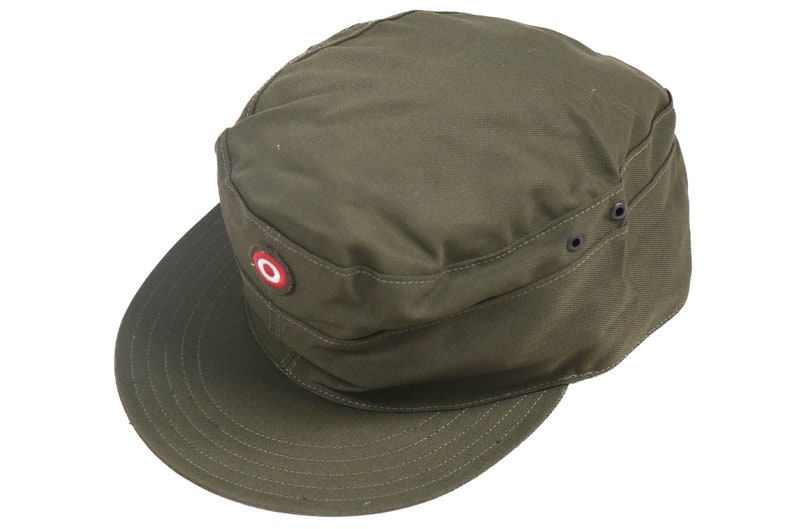 K&ouml;nnte beinhalten: Eine gr&uuml;ne Milit&auml;rkappe mit einem roten Kreis-Patch und schwarzen Knopf-Akzenten.