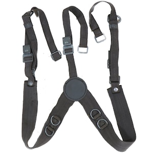 May include: A pair of brown canvas braces with metal buckles and rings. The braces have a black padded section in the centre.