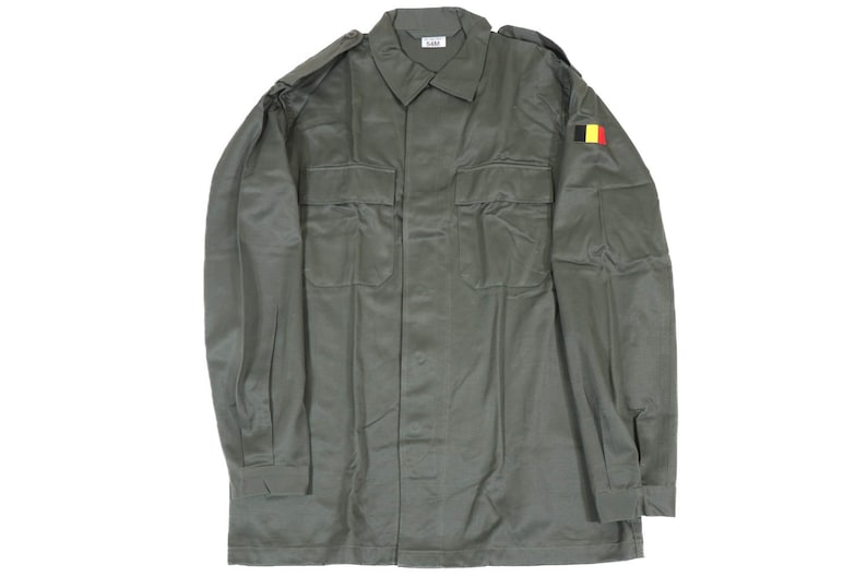 K&ouml;nnte beinhalten: Ein gr&uuml;nes Hemd im Milit&auml;rstil mit langen &Auml;rmeln und Knopfleiste. Das Hemd hat einen Aufn&auml;her mit der belgischen Flagge am rechten &Auml;rmel.