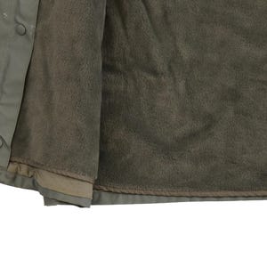 Puede incluir: Una chaqueta verde con forro polar. La chaqueta est&aacute; abierta, mostrando el forro polar.