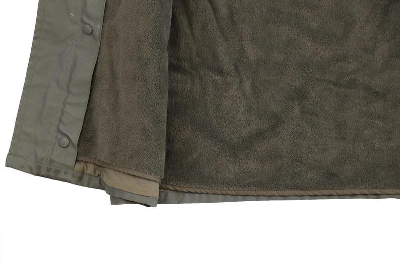 Puede incluir: Una chaqueta verde con forro polar. La chaqueta est&aacute; abierta, mostrando el forro polar.