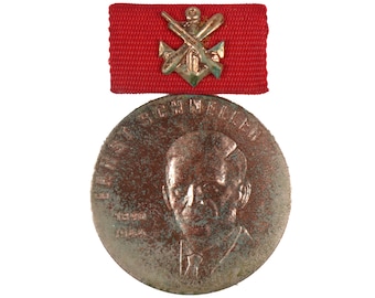 May include: A bronze medal with a portrait of a man and the text "F.J. SCHMIDT" around the edge. The medal is attached to a red ribbon with a gold anchor and crossed rifles.