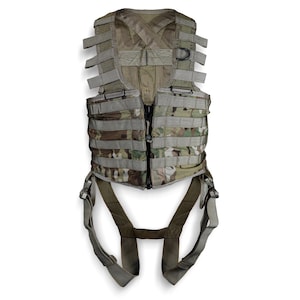 May include: A tactical vest featuring a multi-colored camouflage pattern with horizontal webbing straps across the front. The garment includes a mesh back panel, a central zipper closure, and integrated leg loops with adjustable buckles for secure attachment.