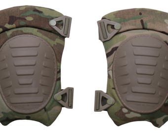 Op de afbeelding: Een paar camouflage kniebeschermers met bruine beschermkappen en verstelbare bandjes. De pads hebben een meerkleurig groen, bruin en tan patroon, met een geribbeld ontwerp op de kniebeschermer. De bandjes hebben een plastic gesp.