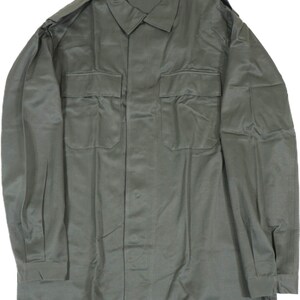K&ouml;nnte beinhalten: Ein gr&uuml;nes, lang&auml;rmliges Utility-Shirt mit Knopfleiste und zwei gro&szlig;en Brusttaschen.