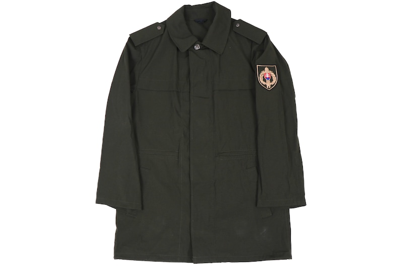 May include: A dark green military-style jacket with a patch on the right sleeve featuring a gold emblem with a red and white design.
