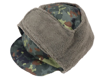 Puede incluir: Un gorro de invierno con estampado de camuflaje y una solapa de oreja de forro polar marrón. El gorro tiene una visera y está hecho de una tela gruesa y duradera.