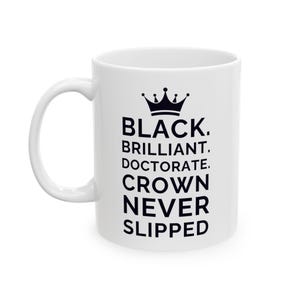 May include: White ceramic mug with a black crown graphic and the words "BLACK. BRILLIANT. DOCTORATE. CROWN NEVER SLIPPED" in a bold, black font. The mug has a curved handle and a glossy finish.