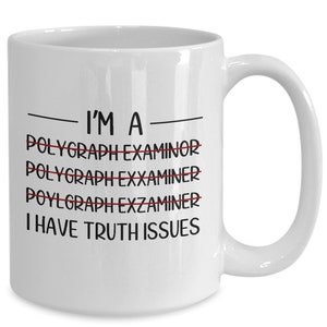 May include: White ceramic mug with a curved handle. The mug features the text "I'M A - POLYGRAPH EXAMINOR - I HAVE TRUTH ISSUES" in black, with the word "POLYGRAPH EXAMINOR" crossed out multiple times in red.