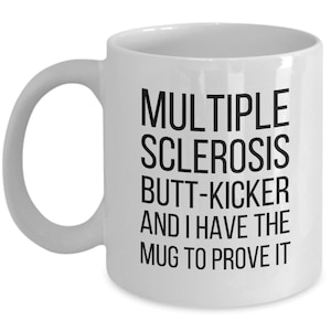 May include: White ceramic coffee mug with black text that reads "Multiple Sclerosis Butt-Kicker and I Have The Mug To Prove It"
