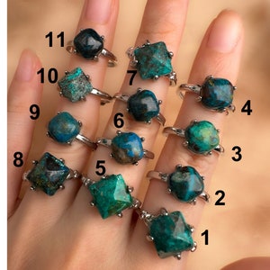 May include: Eleven silver rings with green and blue gemstone settings. The rings are numbered 1 through 11.