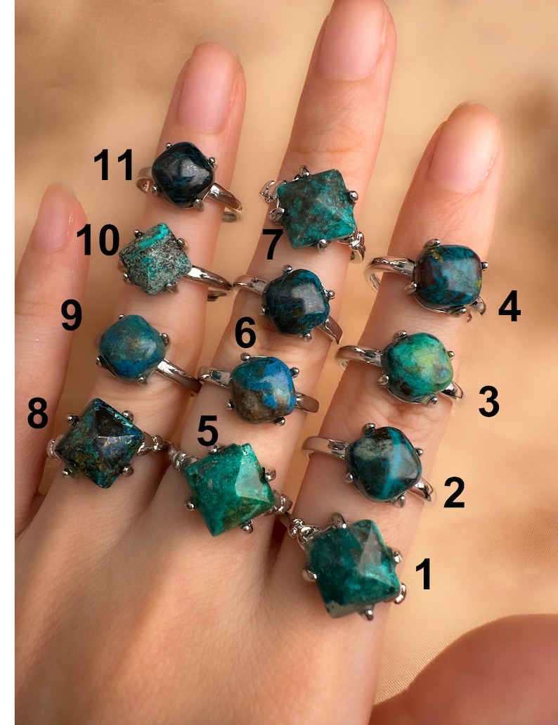 May include: Eleven silver rings with green and blue gemstone settings. The rings are numbered 1 through 11.