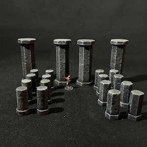 May include: A set of 16 grey stone pillars, some stacked to form columns, with a miniature figure standing in the center.