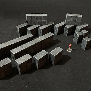 May include: A set of gray stone wall pieces for tabletop gaming. The pieces are made of a textured plastic and are designed to look like rough-hewn stone. The set includes a variety of sizes and shapes, allowing for the creation of a variety of walls and structures.