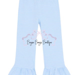 May include: Light blue and white striped pants with ruffled hems. The pants feature a horizontal stripe pattern and the text "Bayou Boogie Boutique" in a cursive font. The pants are designed for children.
