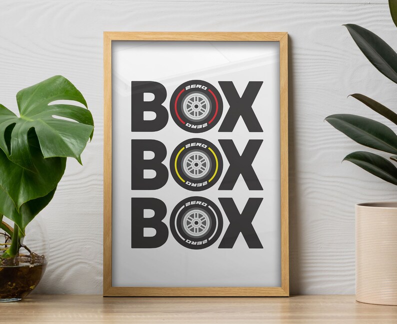 May include: A framed print with the word "BOX" repeated three times, each time with a different tire design in black, yellow, and red. The tires are labeled "ZERO"
