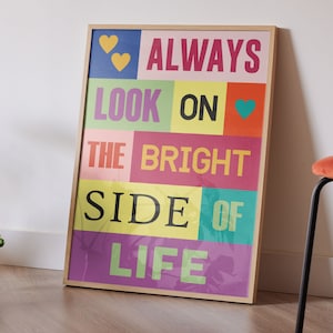 Può includere: Una stampa incorniciata con un design colorato e il testo "ALWAYS LOOK ON THE BRIGHT SIDE OF LIFE". La stampa ha uno sfondo rosa, giallo, verde, blu e viola con testo bianco.